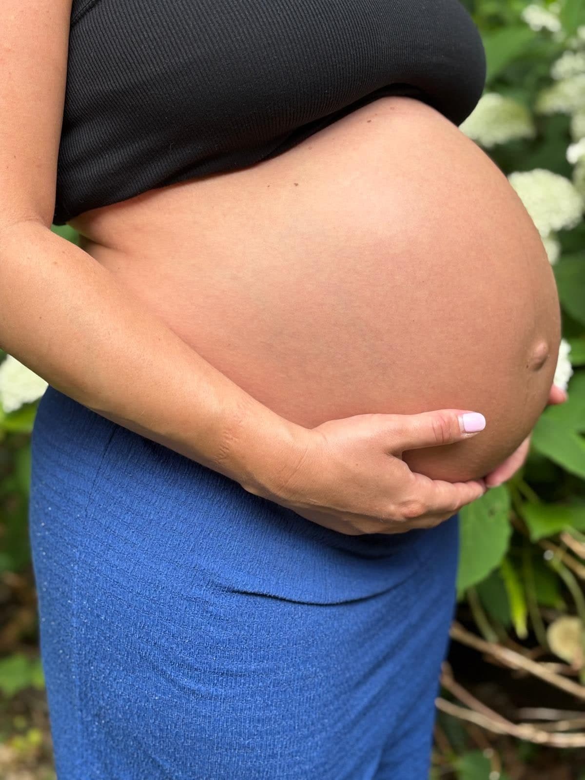 Femme enceinte tenant son ventre entre ses mains
